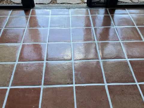 After: Dull, worn Mexican Saltillo tile floor before and a rich glossy finish after stripping and resealing